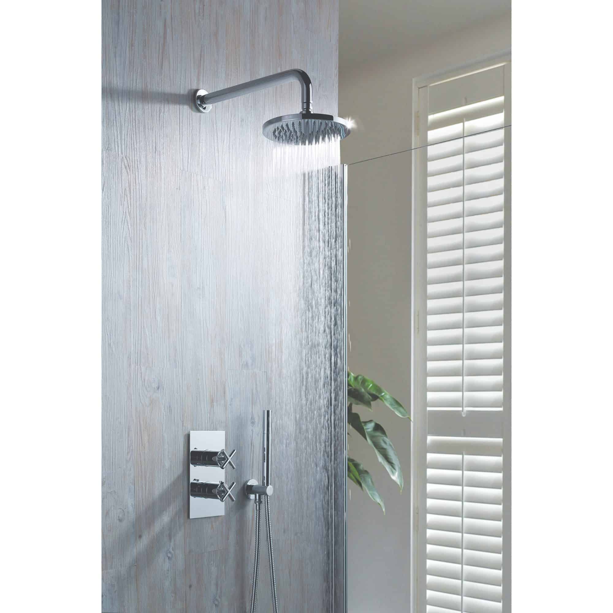 Shower head with rainfall water flow in modern bathroom, chrome fixtures and textured grey wall, near white plantation shutters, contemporary shower design for luxury bathroom detailing.