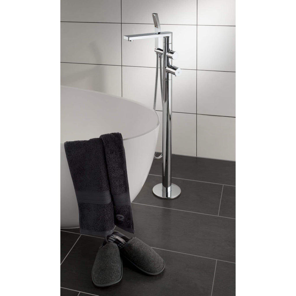 Stylish chrome freestanding bathtub tap with handheld shower and towel hooks on a modern bathroom wall, offering elegant bathroom fixtures for a luxurious bathing experience.