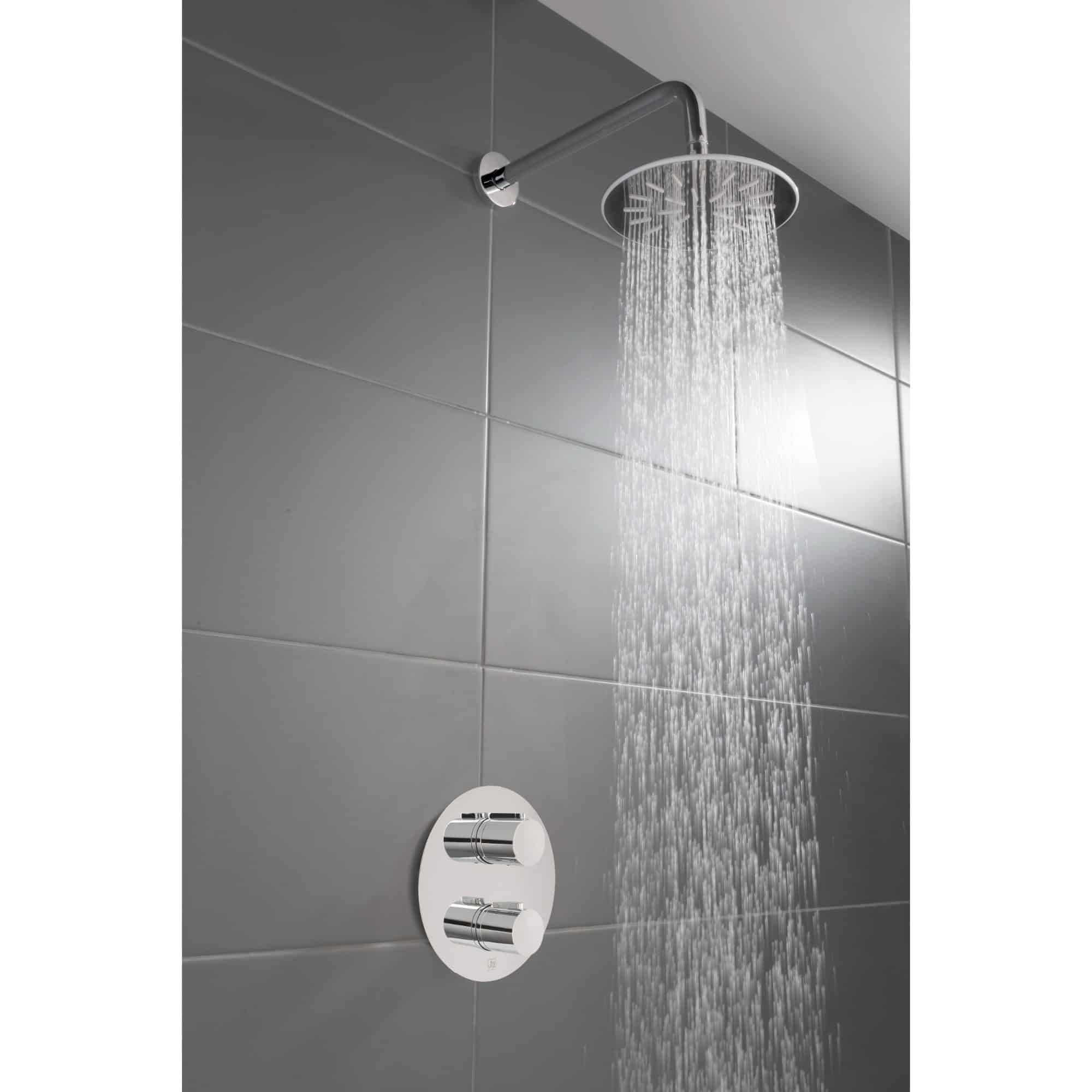 Modern chrome showerhead with rainfall spray in a contemporary bathroom featuring grey tiled walls.