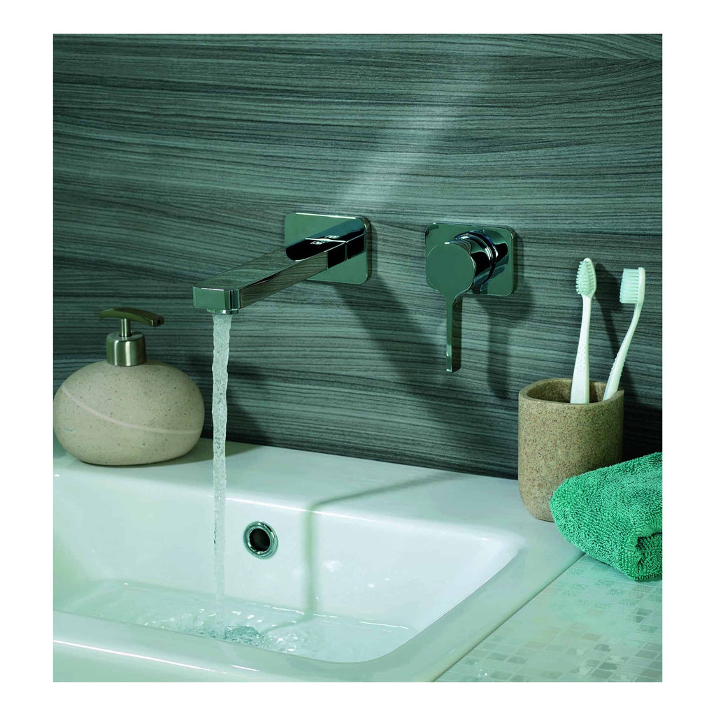 Sleek modern chrome bathroom tap and wall-mounted fixtures with a white ceramic sink, toothbrush holder, and soft green towel, perfect for contemporary bathroom design and hygiene.