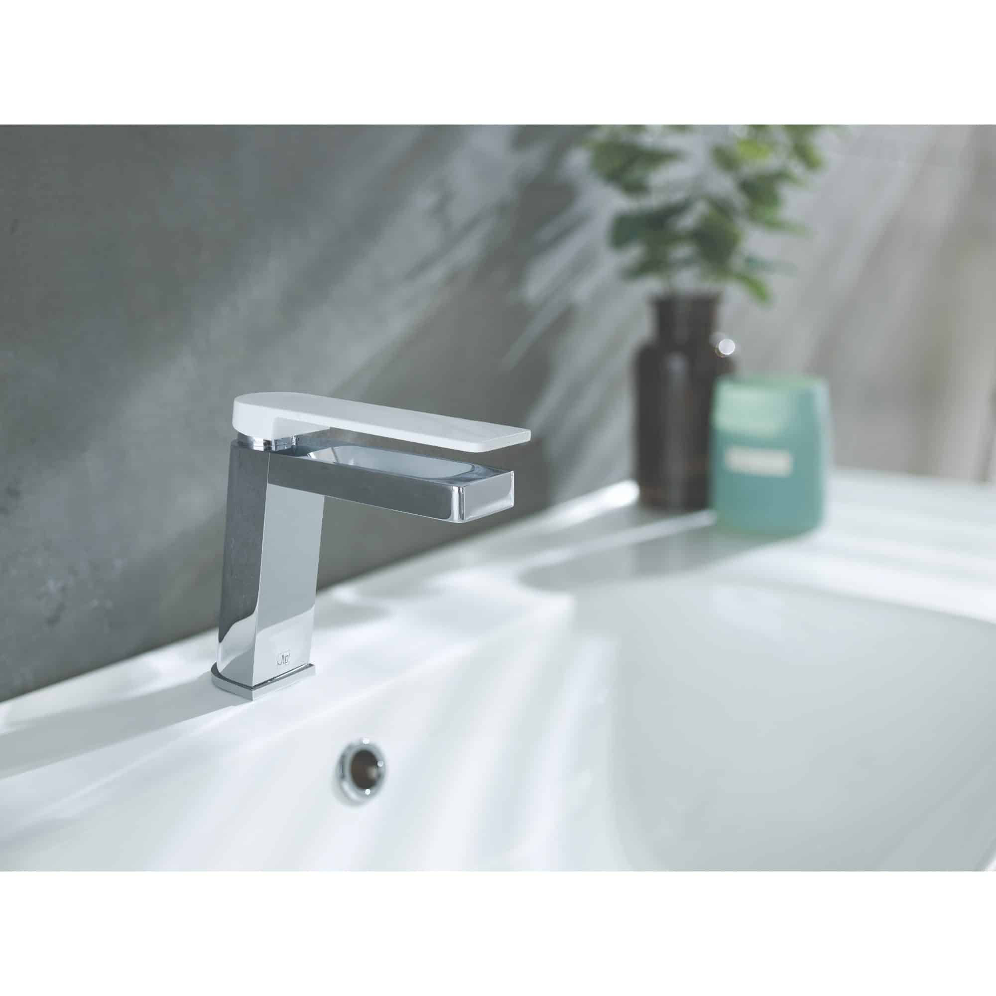 Sleek modern chrome bathroom sink tap with white handle, minimalist design.