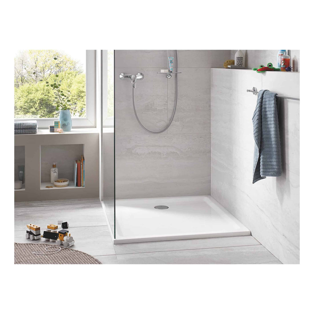 Shower area with a modern, minimalist design featuring a walk-in shower with a handheld showerhead, light grey marble walls, and a white shower tray, ideal for contemporary bathrooms.