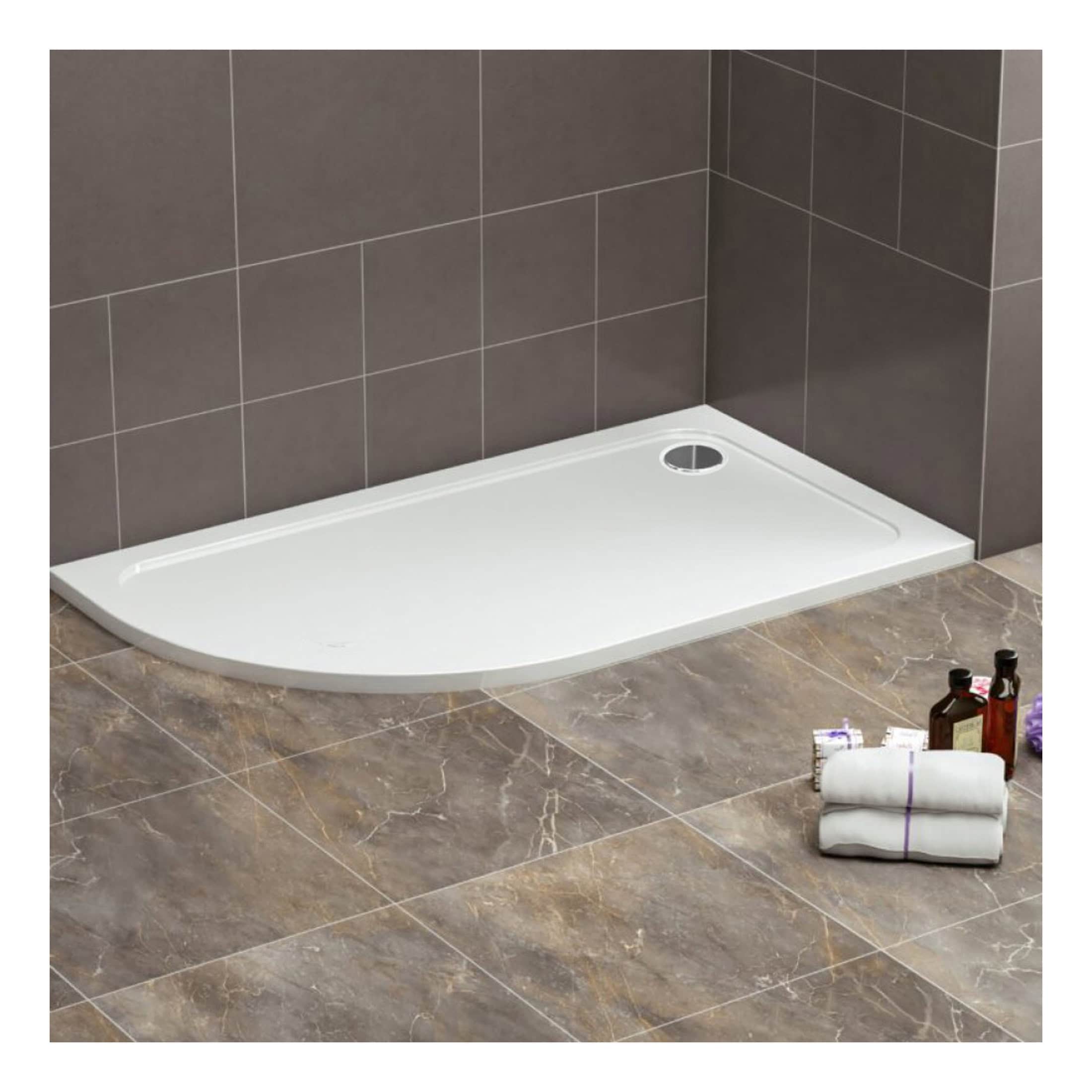 Modern white shower tray with a sleek design, chrome drain cover, in a contemporary bathroom setting with brown tiled walls and marble effect floor tiles.
