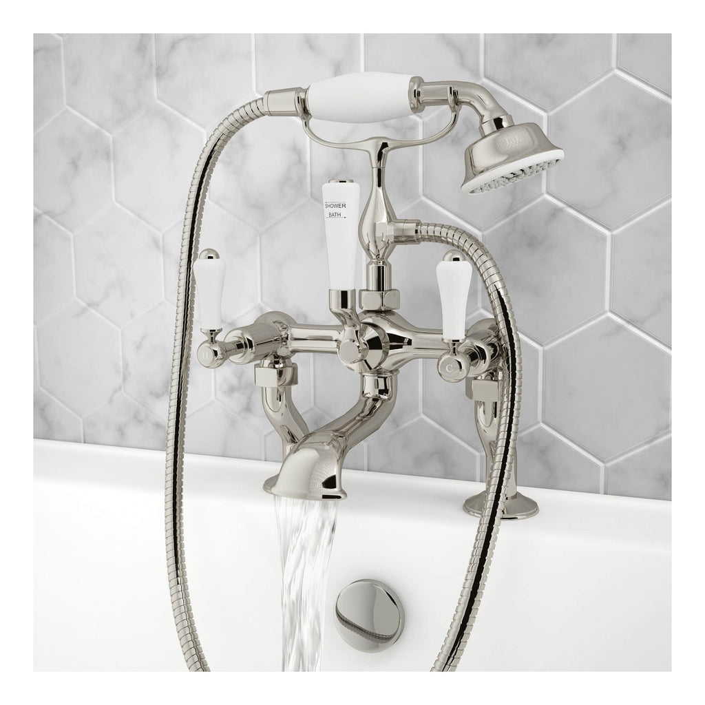 Shiny chrome bathtub mixer tap with handheld shower attachment and white control handles, mounted on a white bathtub with a modern tiling background for stylish bathroom decor.