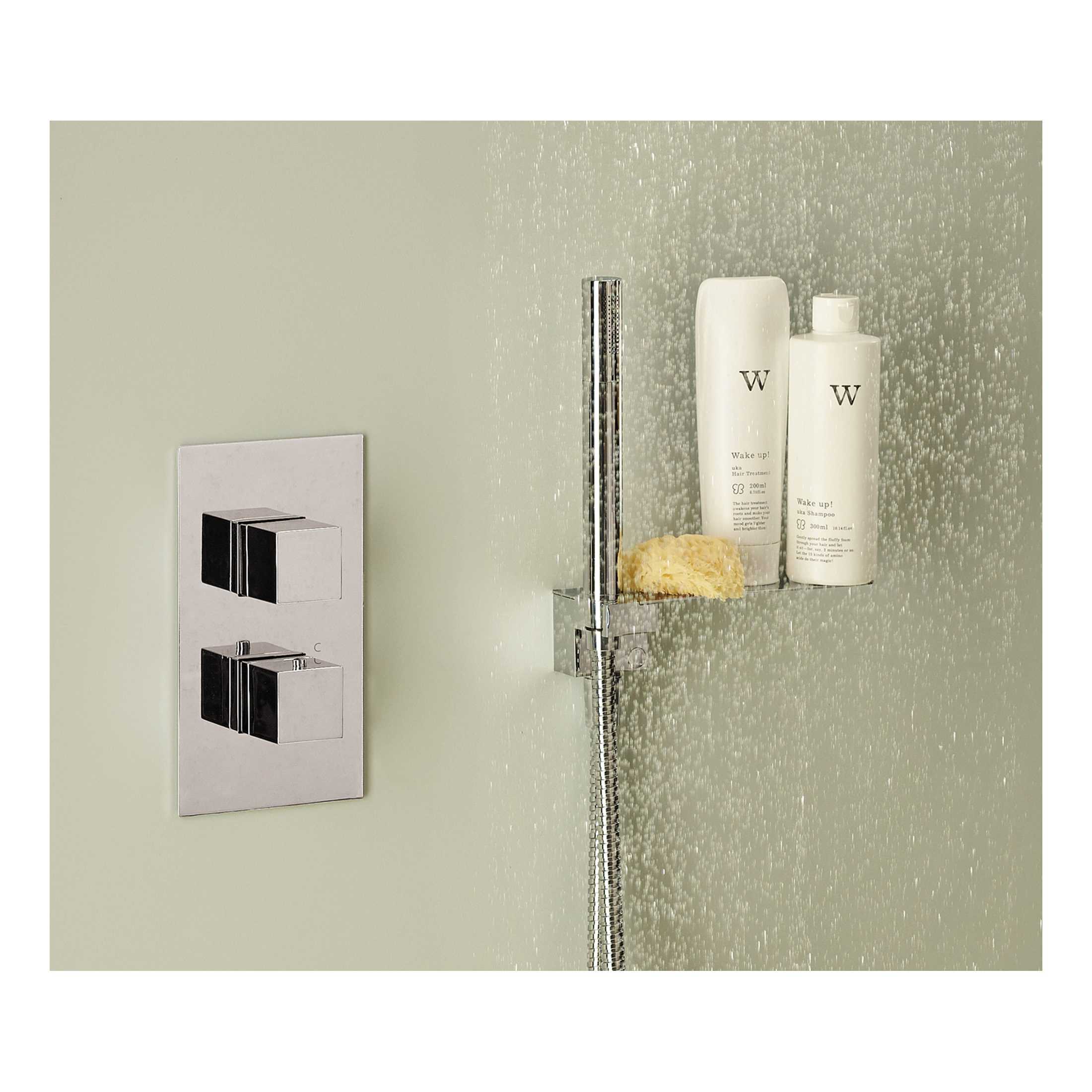 Shower head with adjustable water flow and chrome finish, mounted on a modern bathroom wall with a built-in shower shelf holding shampoo, conditioner, and a sponge for luxury bath experience.