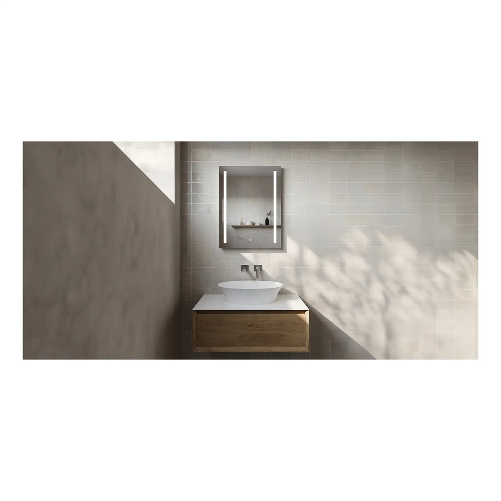 Sleek modern bathroom vanity with a white vessel sink, wall-mounted mirror with integrated lighting, minimalist wooden cabinet, neutral tiled wall, and natural light creating a clean and contemporary bathroom design.