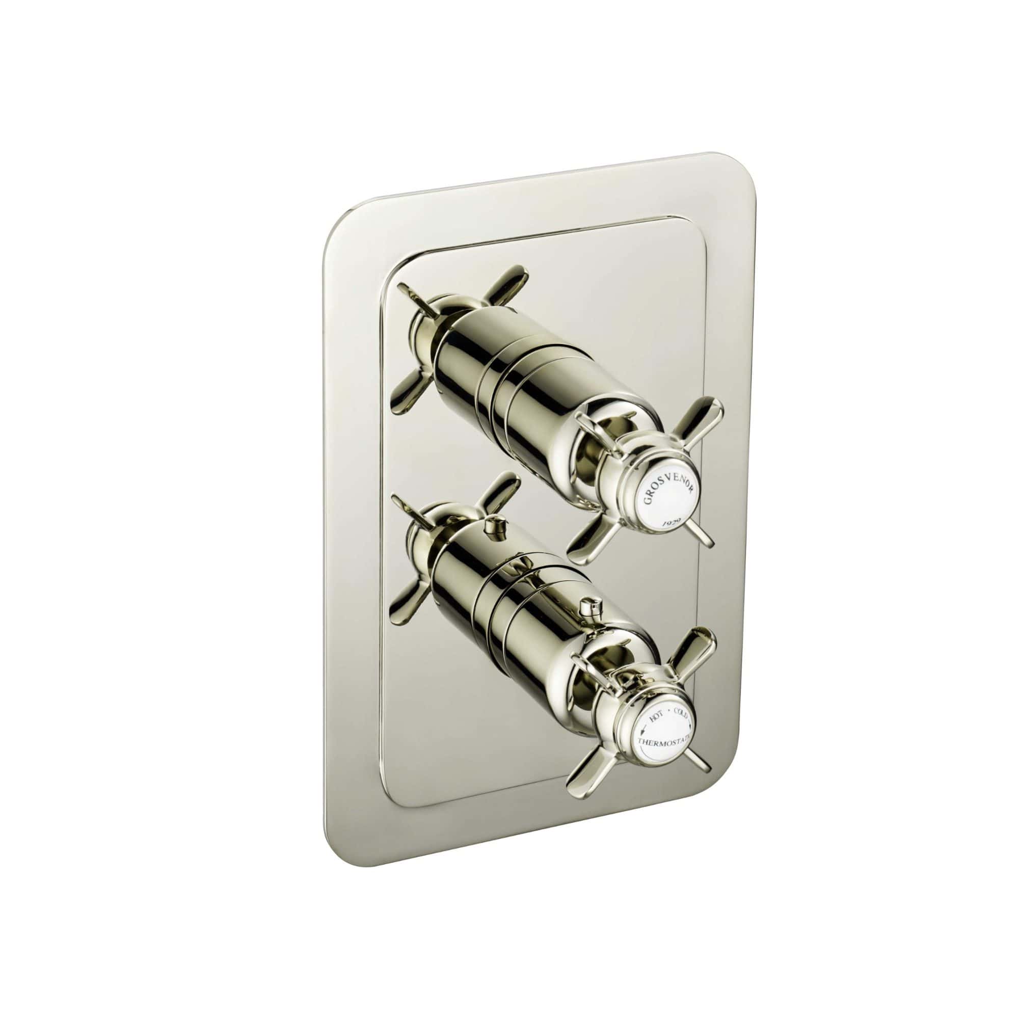 Polished chrome bathroom mixing valve with dual handles for hot and cold water control, mounted on a reflective wall plate, ideal for modern bathroom installations.