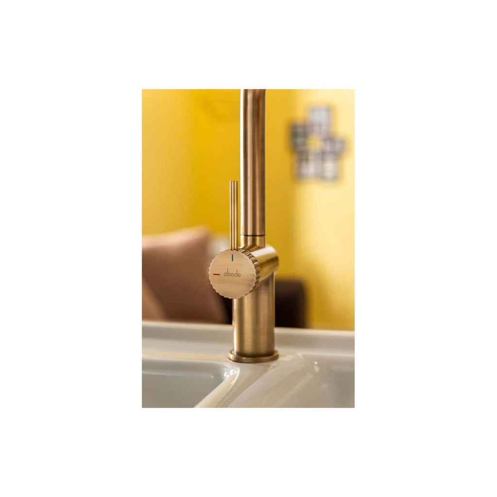 Shiny gold kitchen tap with adjustable temperature control set against a yellow wall, part of Bubly Bathrooms' modern kitchen fixtures. Perfect for enhancing contemporary kitchen style and functionality.