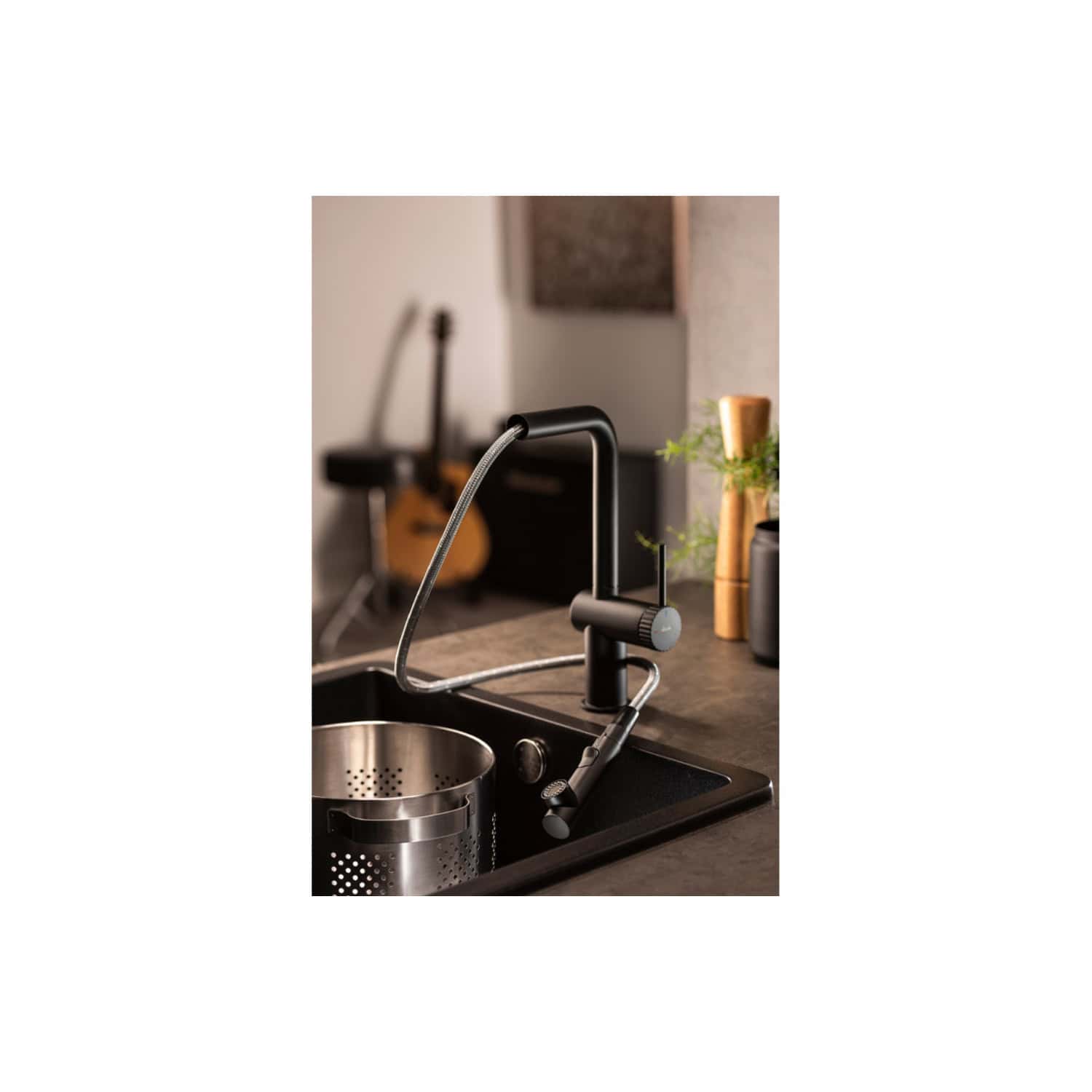 Sleek black kitchen tap with pull-out spray in modern kitchen setting, close-up view showcasing stylish design and functionality.