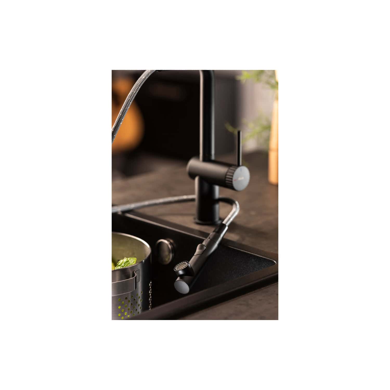 Sleek black and grey modern kitchen faucet with pull-out spray head, installed on a black sink, featuring a minimalist design perfect for contemporary bathrooms and kitchens.