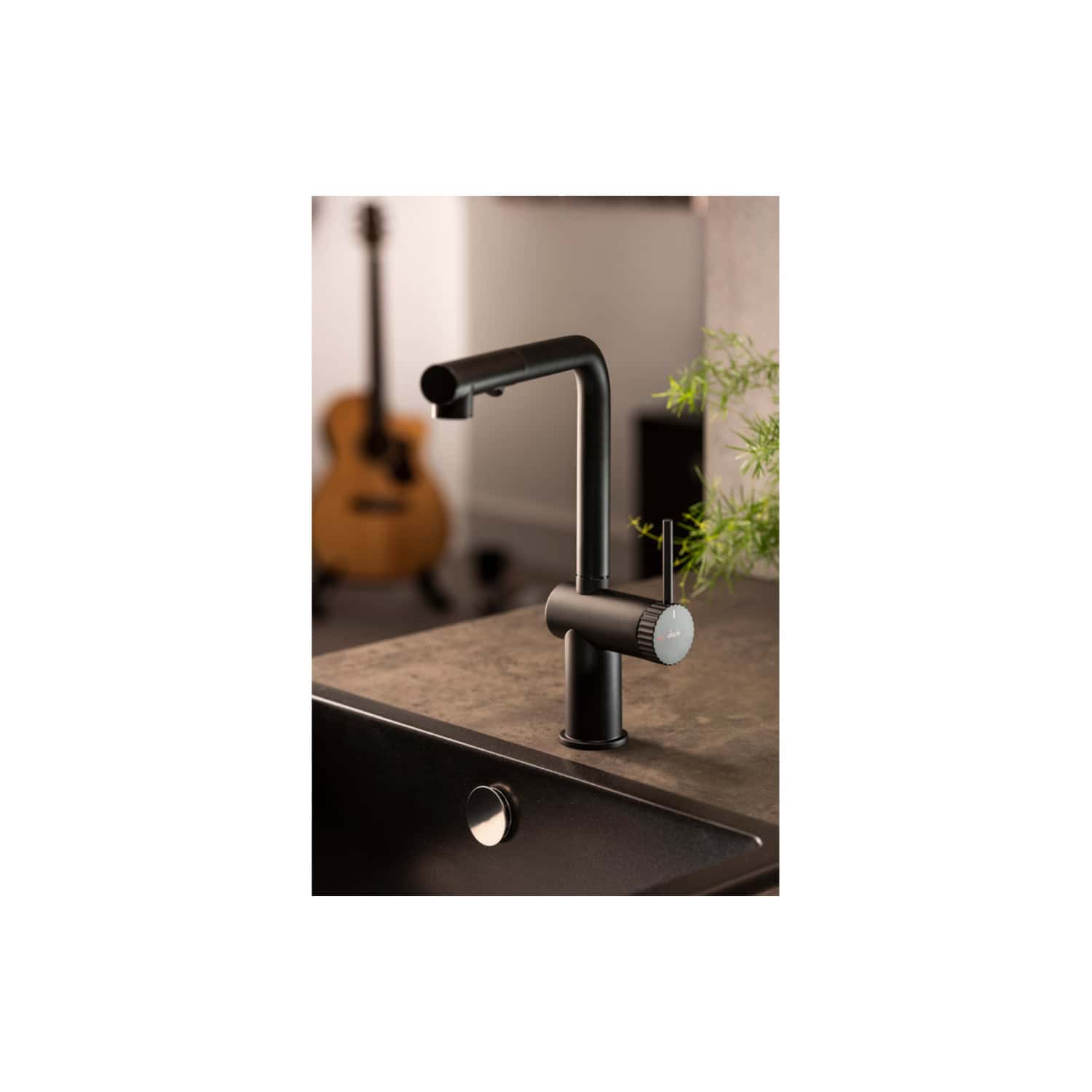 High-quality black kitchen tap with modern design, featuring a pull-out spray head, installed on a dark stone countertop with greenery in the background, perfect for contemporary bathrooms.