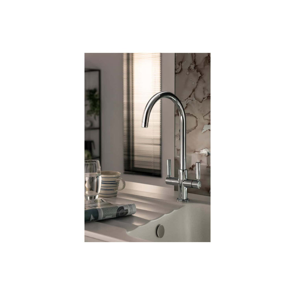 Sleek chrome kitchen tap with modern design on a white sink in a contemporary bathroom setting.