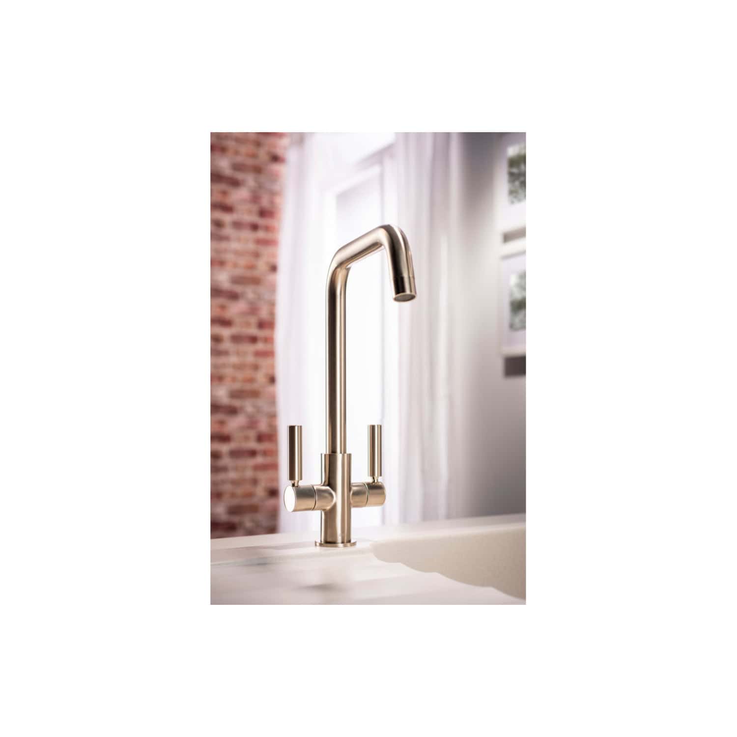 Brushed gold modern kitchen sink tap for contemporary bathroom or kitchen, featuring dual lever handles and high-arc spout, in a bright natural light setting.