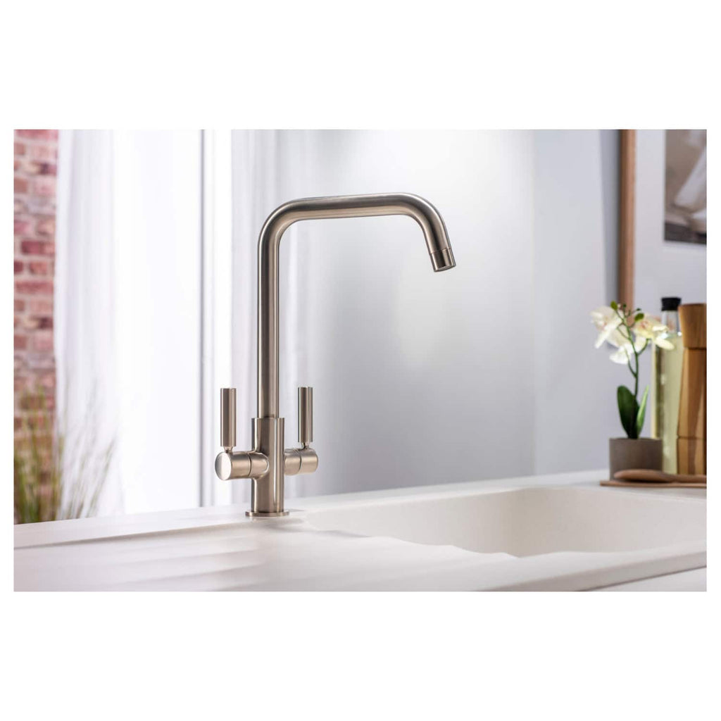 Polished stainless steel kitchen faucet with modern design, high-arc spout, and dual handles, installed on a white kitchen sink in a contemporary kitchen setting.