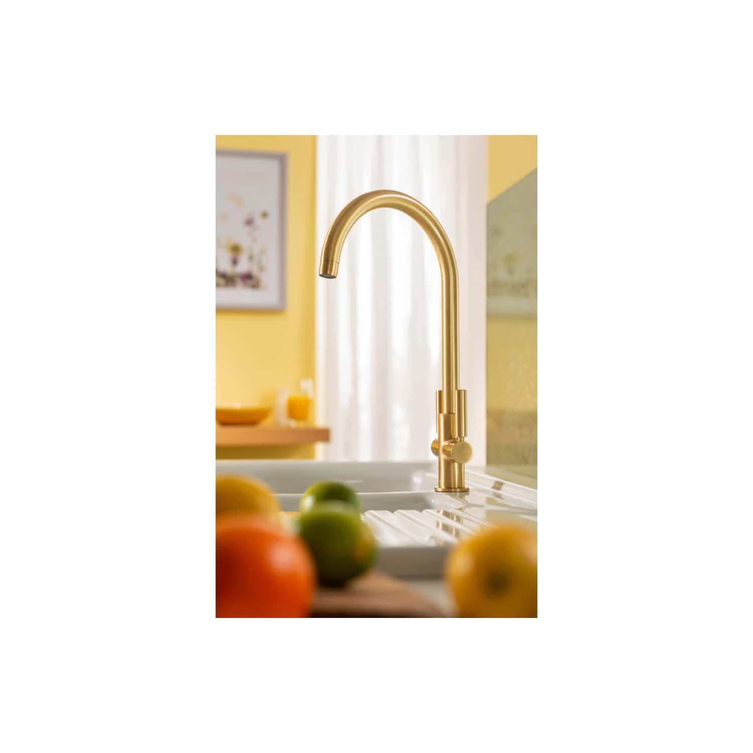 Sleek gold kitchen tap in a modern kitchen setting with fresh fruits in the foreground, highlighting stylish and functional kitchen fixtures for contemporary home design.