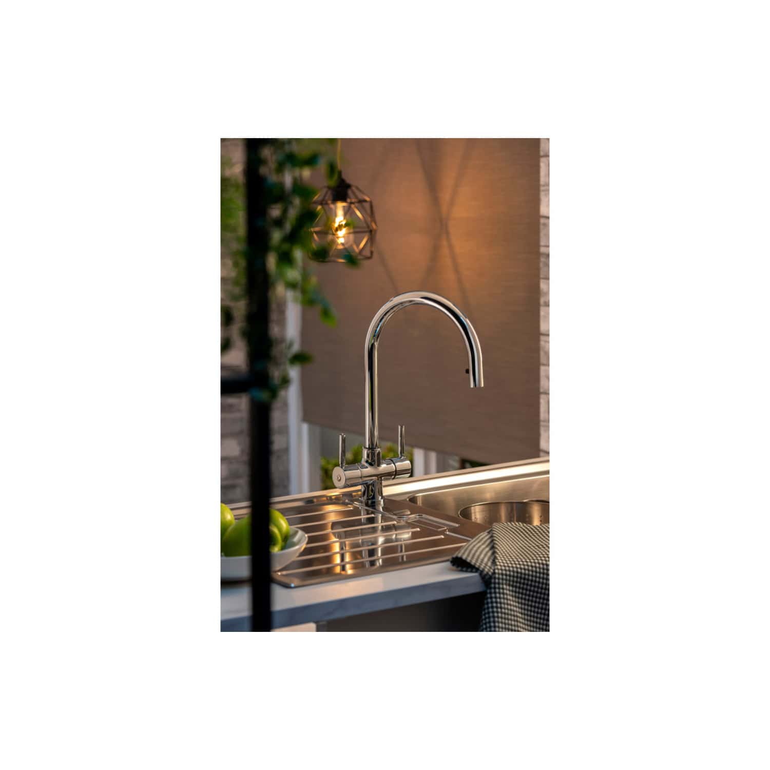 Luxury modern kitchen stainless steel sink with high-arc mixer faucet and side draining board, illuminated by ambient lighting, featuring a cosy outdoor dining area, perfect for contemporary home kitchens and outdoor entertaining.