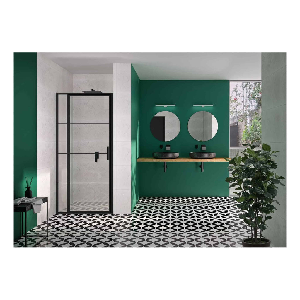 Sleek modern bathroom with dual black vessel sinks, round mirrors, green accent wall, and stylish black and white geometric patterned floor tiles, creating a contemporary and inviting spa-like retreat.