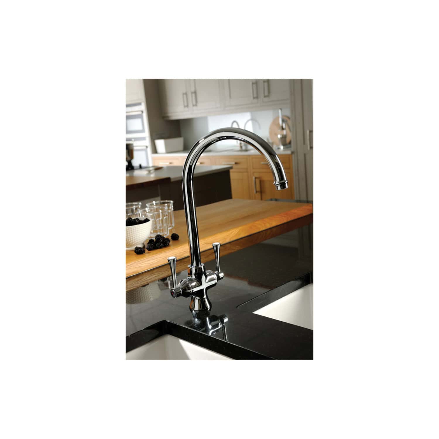 Shiny chrome kitchen mixer tap with a curved spout in a modern kitchen setting, featuring wooden countertops and a black sink for contemporary kitchen design.