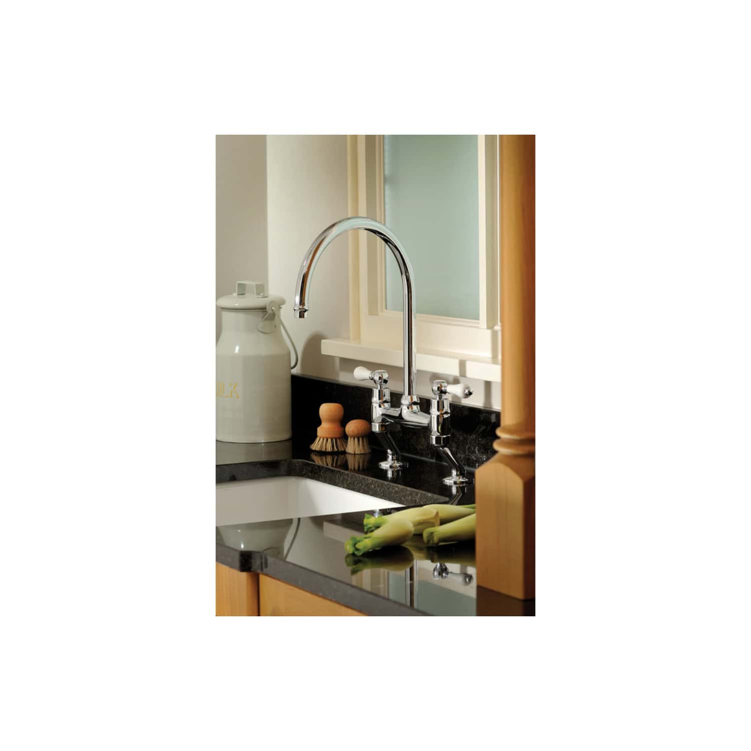 Shiny kitchen sink with chrome faucet in modern kitchen, featuring black countertop, wooden cabinets, and fresh vegetables, highlighting stylish bathroom or kitchen fixtures.