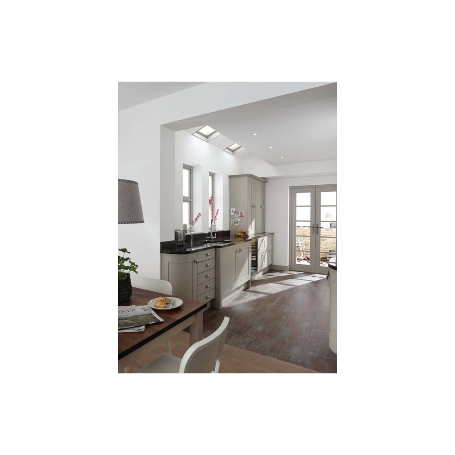 Modern kitchen with natural light, grey cabinets, black countertop, and wood flooring, featuring stylish fixtures and elegant design, perfect for contemporary home interiors.