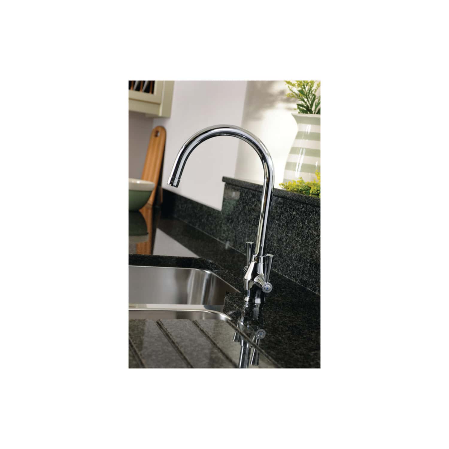 Stainless steel kitchen tap with curved design on black granite countertop in modern bathroom or kitchen setting.