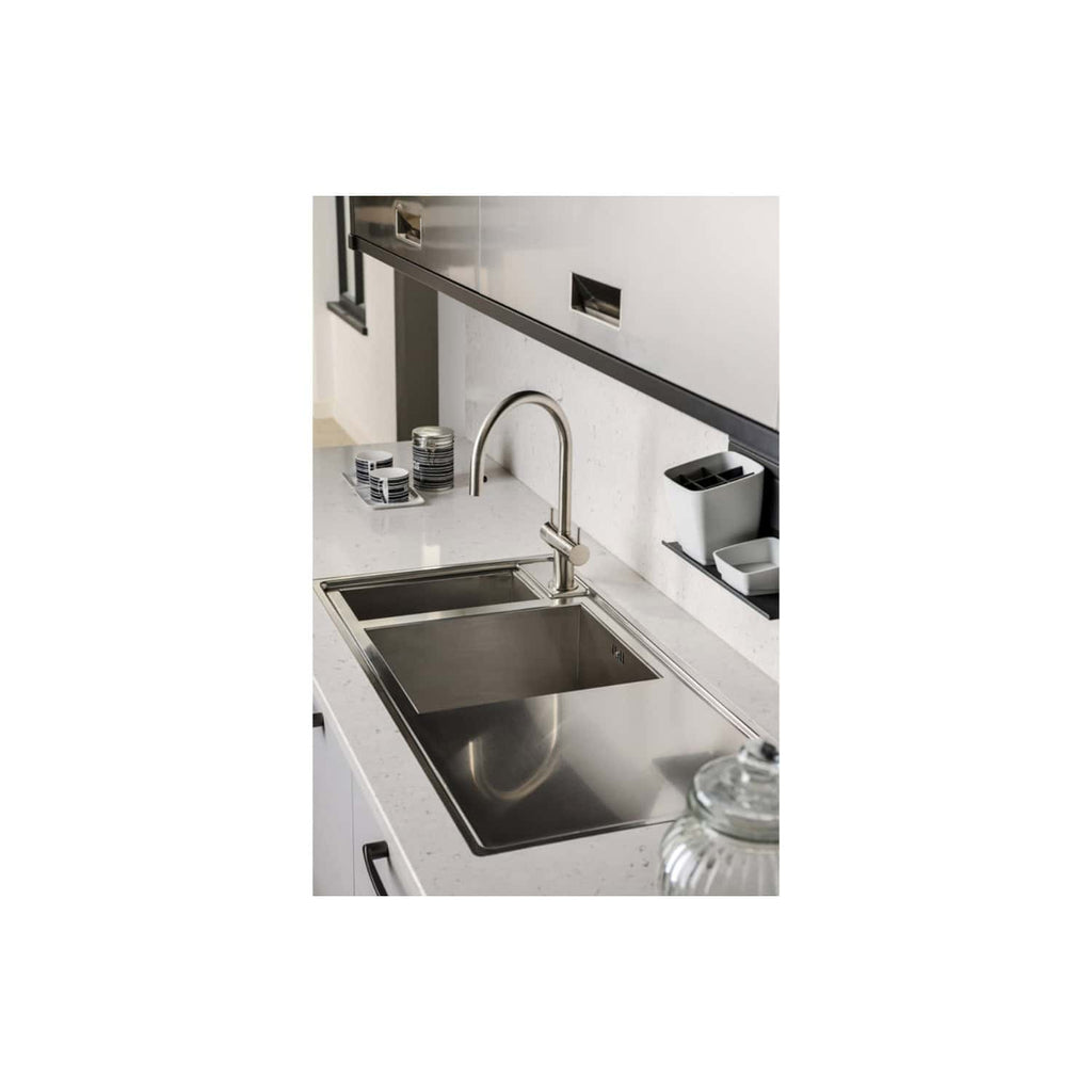 Stainless steel kitchen sink with modern faucet in a contemporary bathroom setting. Features clean design, white countertop, and organised accessories for optimal bathroom functionality.