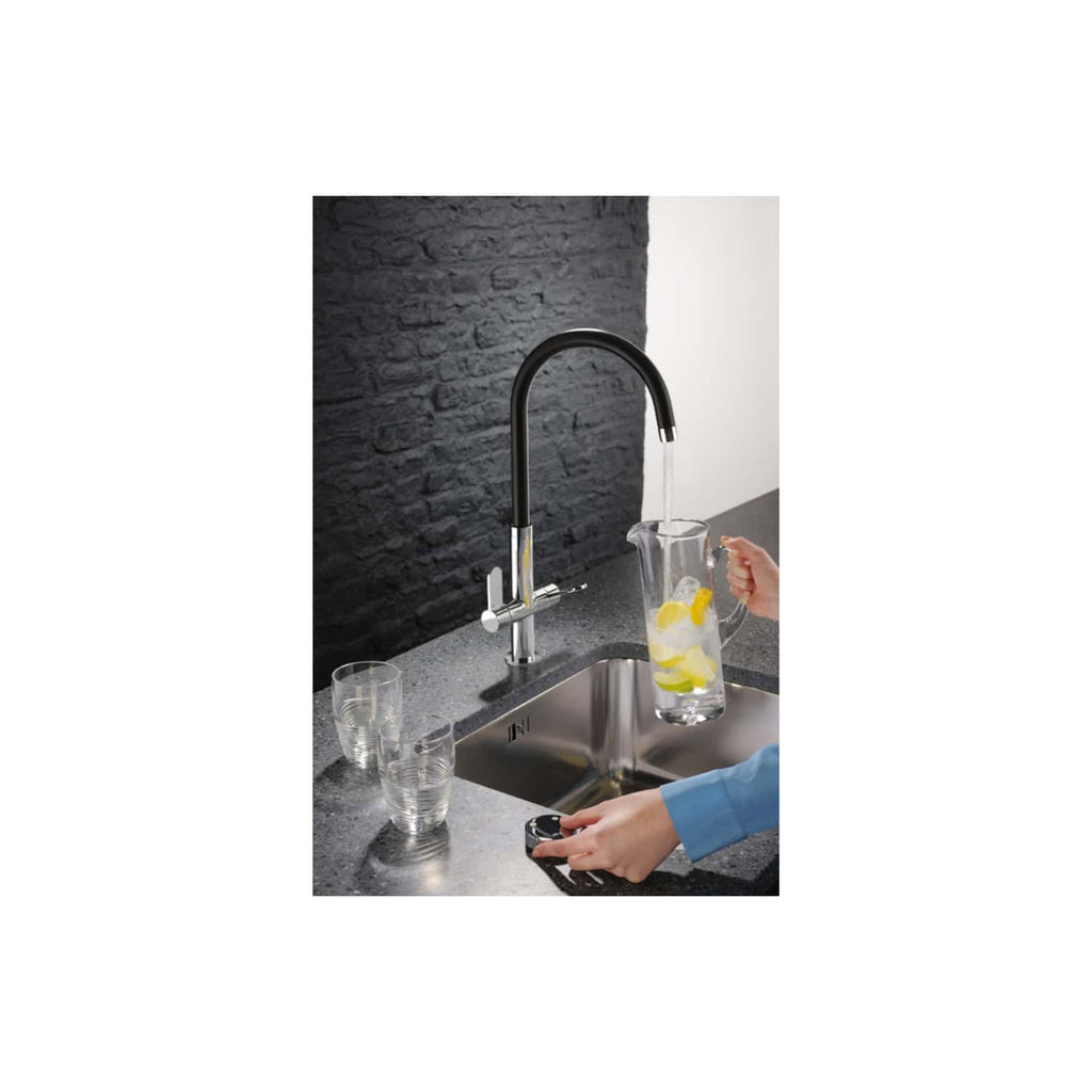 Faucet with modern black finish, pouring water into a glass pitcher with lemons in a contemporary kitchen sink setup, featuring a textured black slate backsplash, two drinking glasses, and a sleek kitchen design.