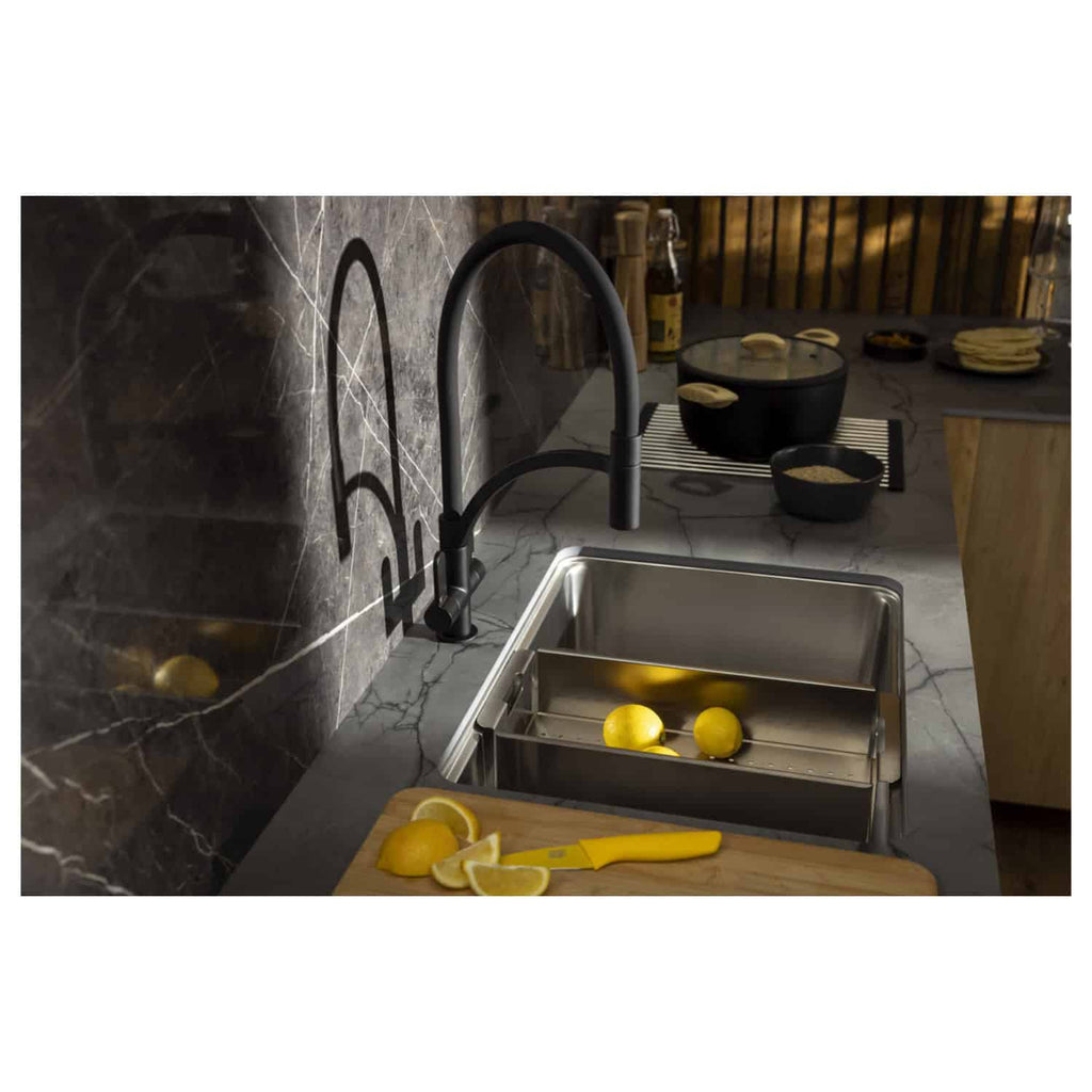 Lemon slicer in stainless steel sink with fresh lemons, black and marble countertop, modern black kitchen faucet, and kitchen accessories, showcasing sleek kitchen design and plumbing fixtures.
