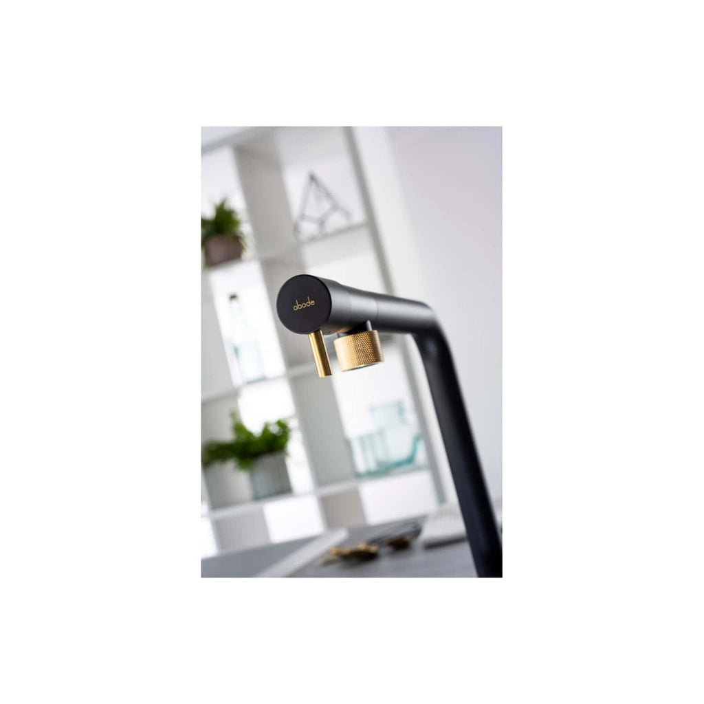 Sleek modern black and gold bathroom tap with "abode" branding, stylish kitchen or bathroom fixture designed for contemporary homes, featuring minimalist design and premium metallic accents.