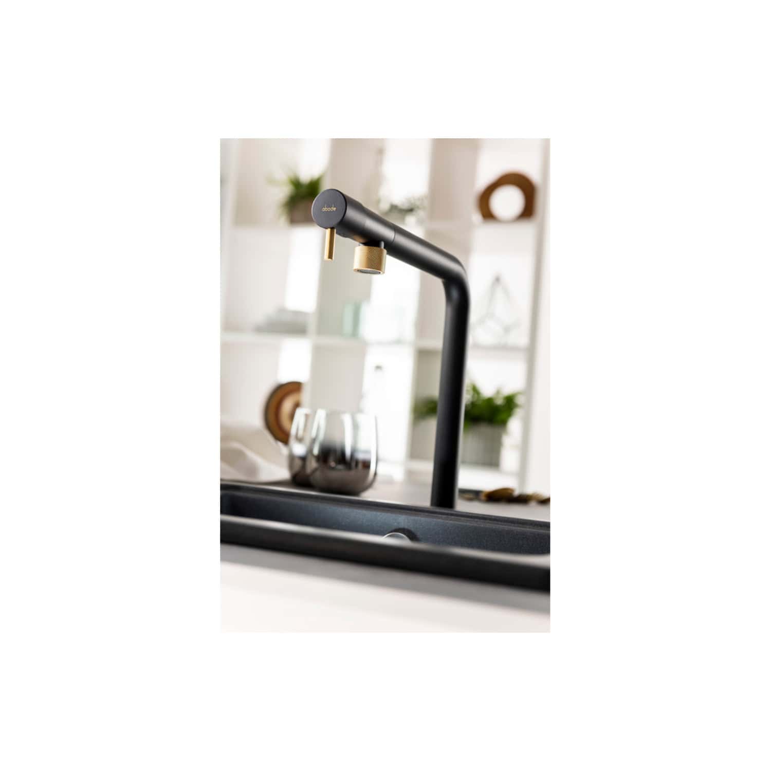 Sleek black kitchen tap with gold accents in modern bathroom setting, featuring a minimalist and contemporary design for stylish and functional kitchen faucets.