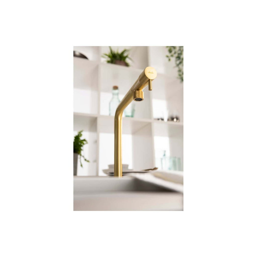 Sleek gold kitchen tap with modern design in contemporary bathroom setting.