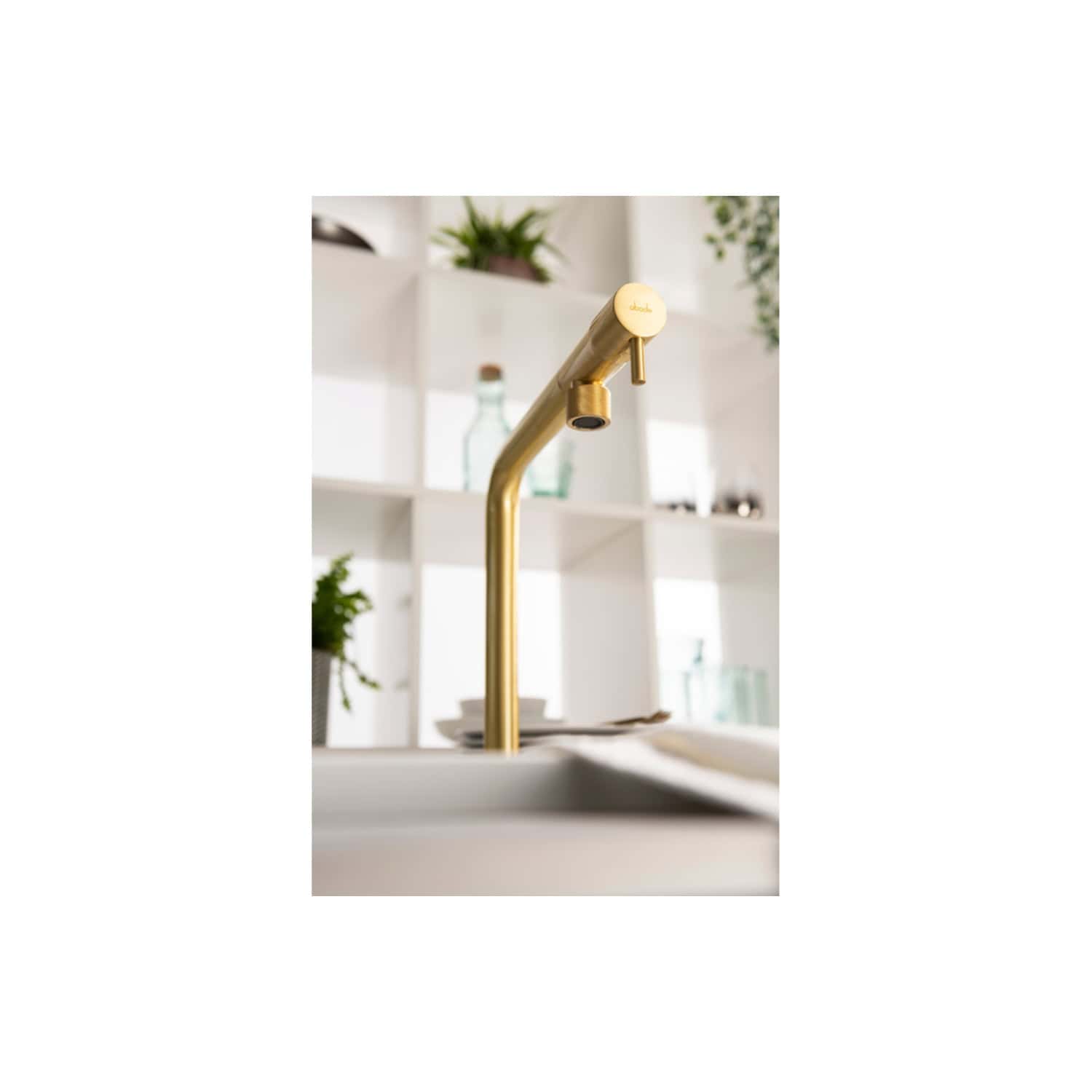Sleek gold kitchen tap with modern design in contemporary bathroom setting.