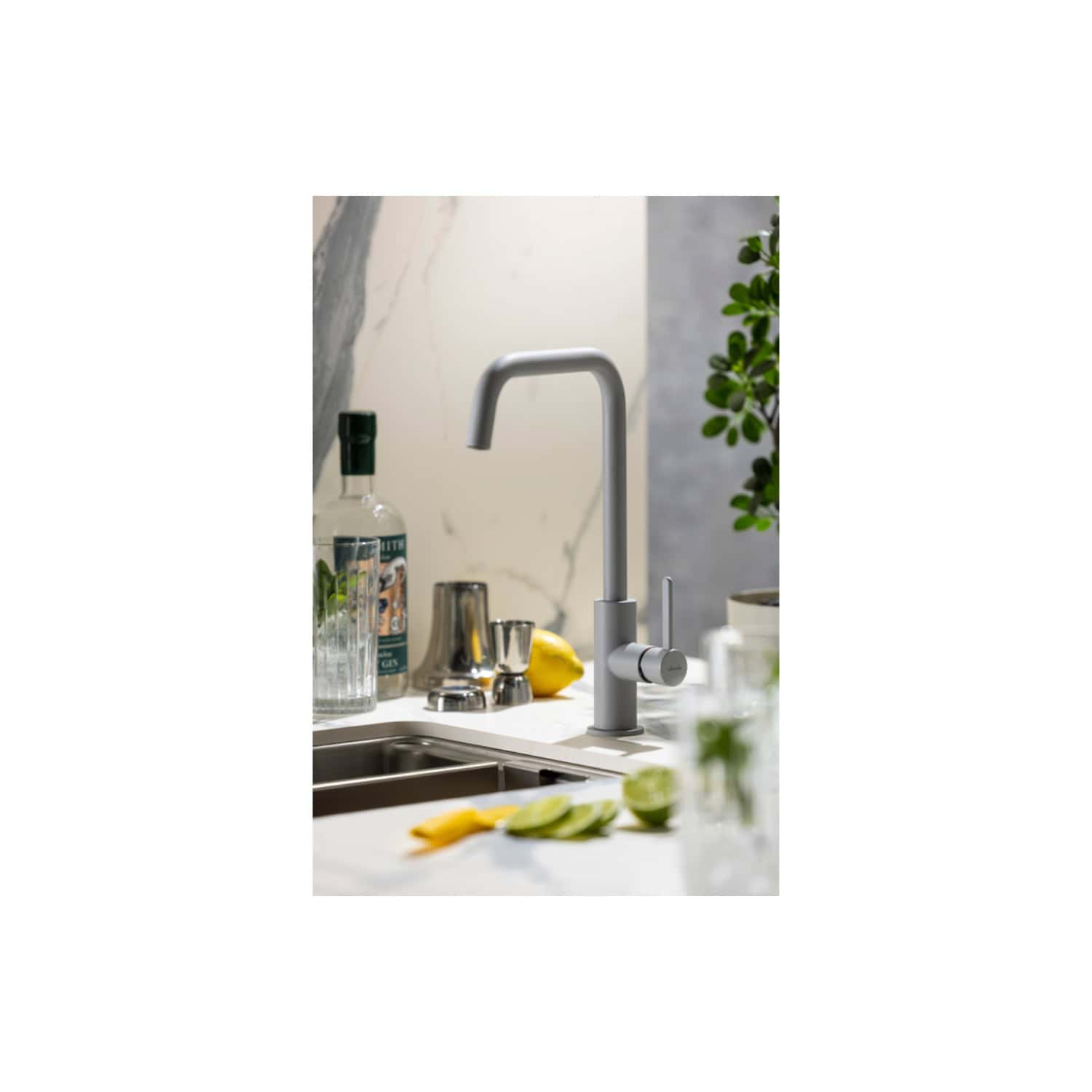 Sleek modern kitchen tap in a contemporary design with a high-arc spout and single lever, installed over a stainless steel sink in a stylish kitchen setting.