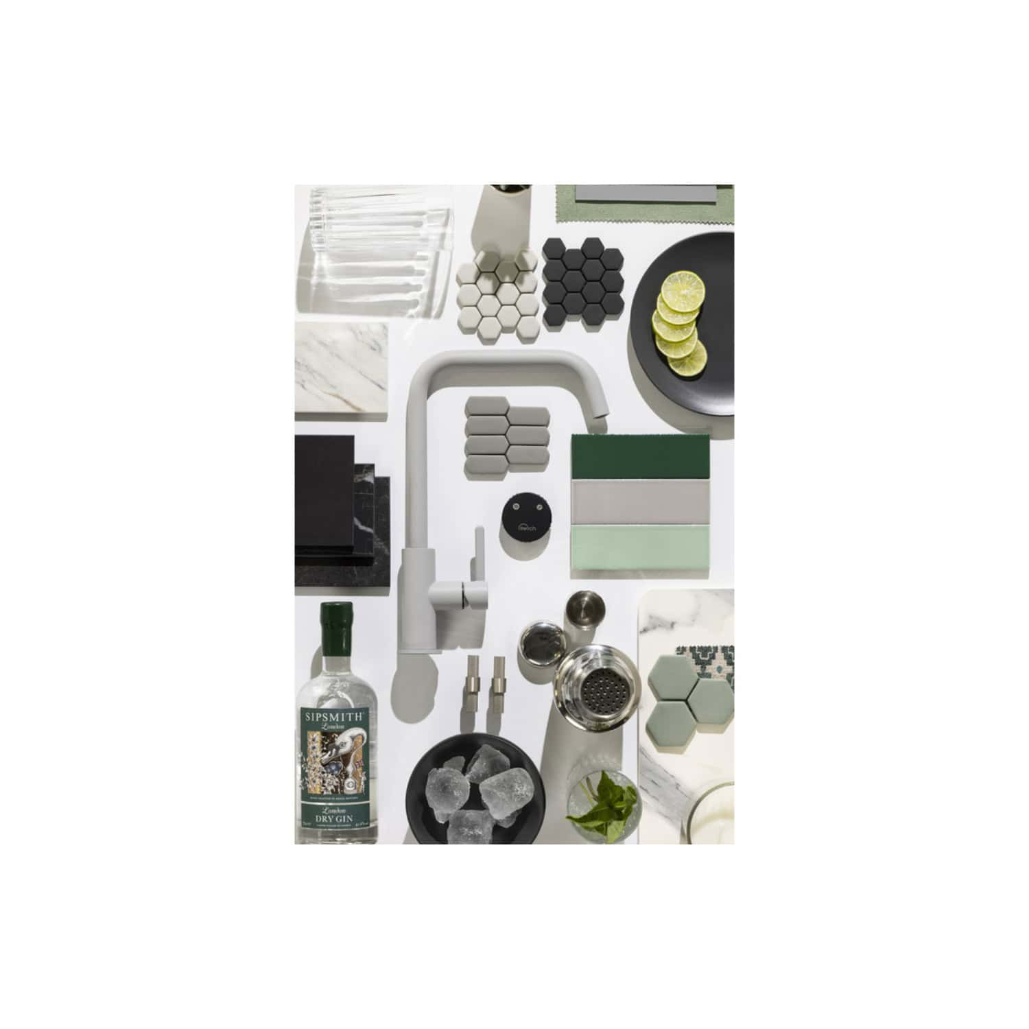 Bright modern bathroom decor with various tiles, a sleek white faucet, glassware, citrus slices, and accessories in neutral tones, perfect for contemporary bathroom design inspiration.