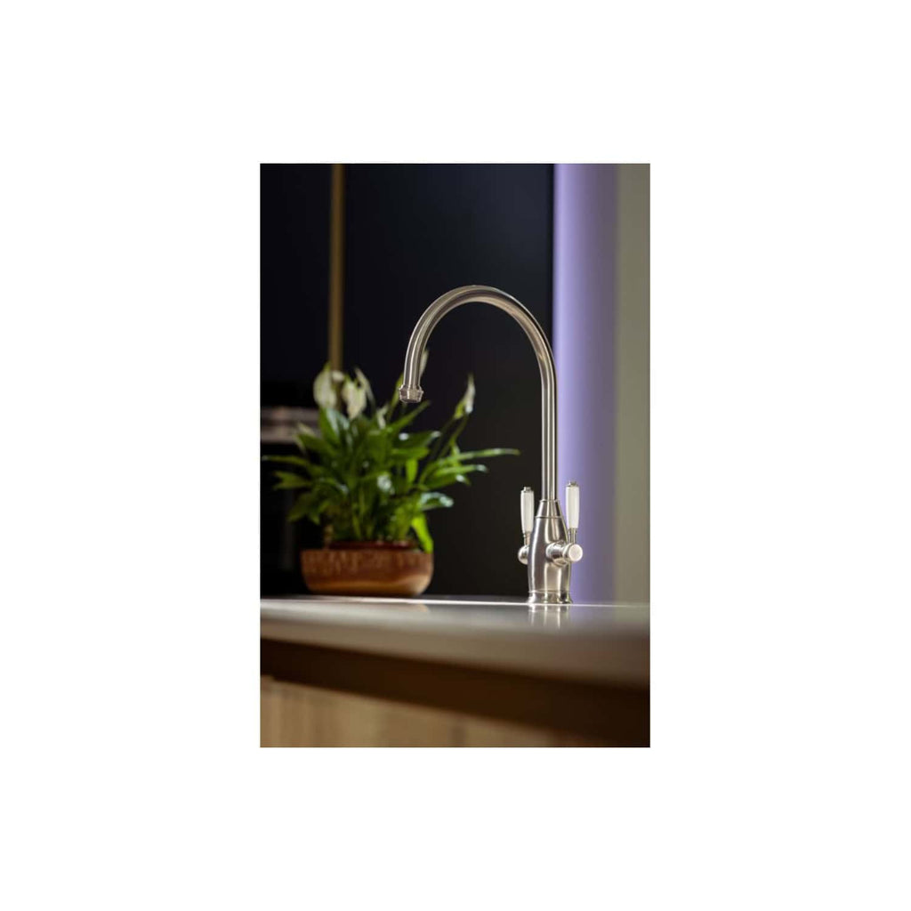 Brushed nickel kitchen tap with a high-arc spout, modern design, installed in a contemporary kitchen with a potted plant in the background, highlighting premium bathroom fixtures and kitchen accessories.
