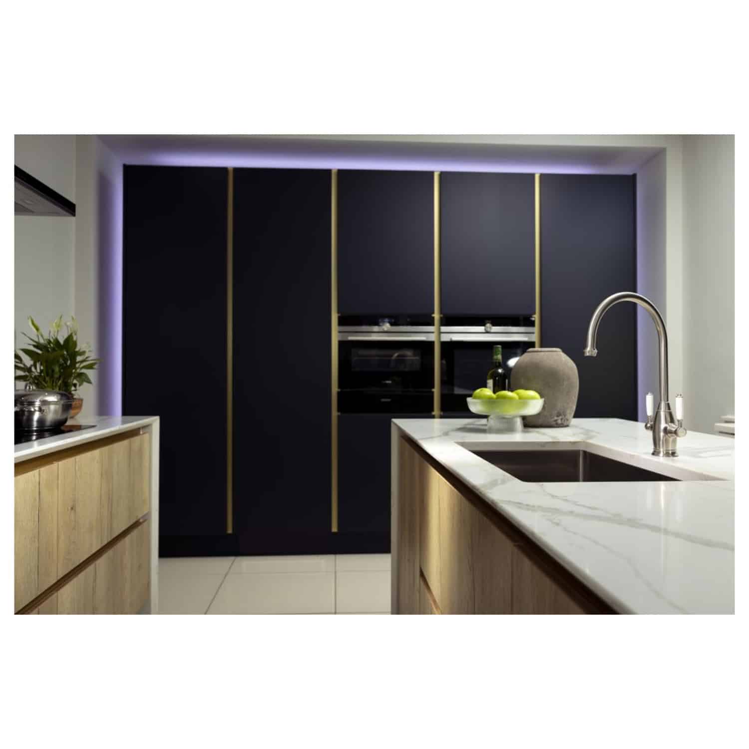 Sleek modern kitchen with black cabinets accented by gold trim, white marble countertops, and stainless steel fixtures, highlighting contemporary design and premium finishes.