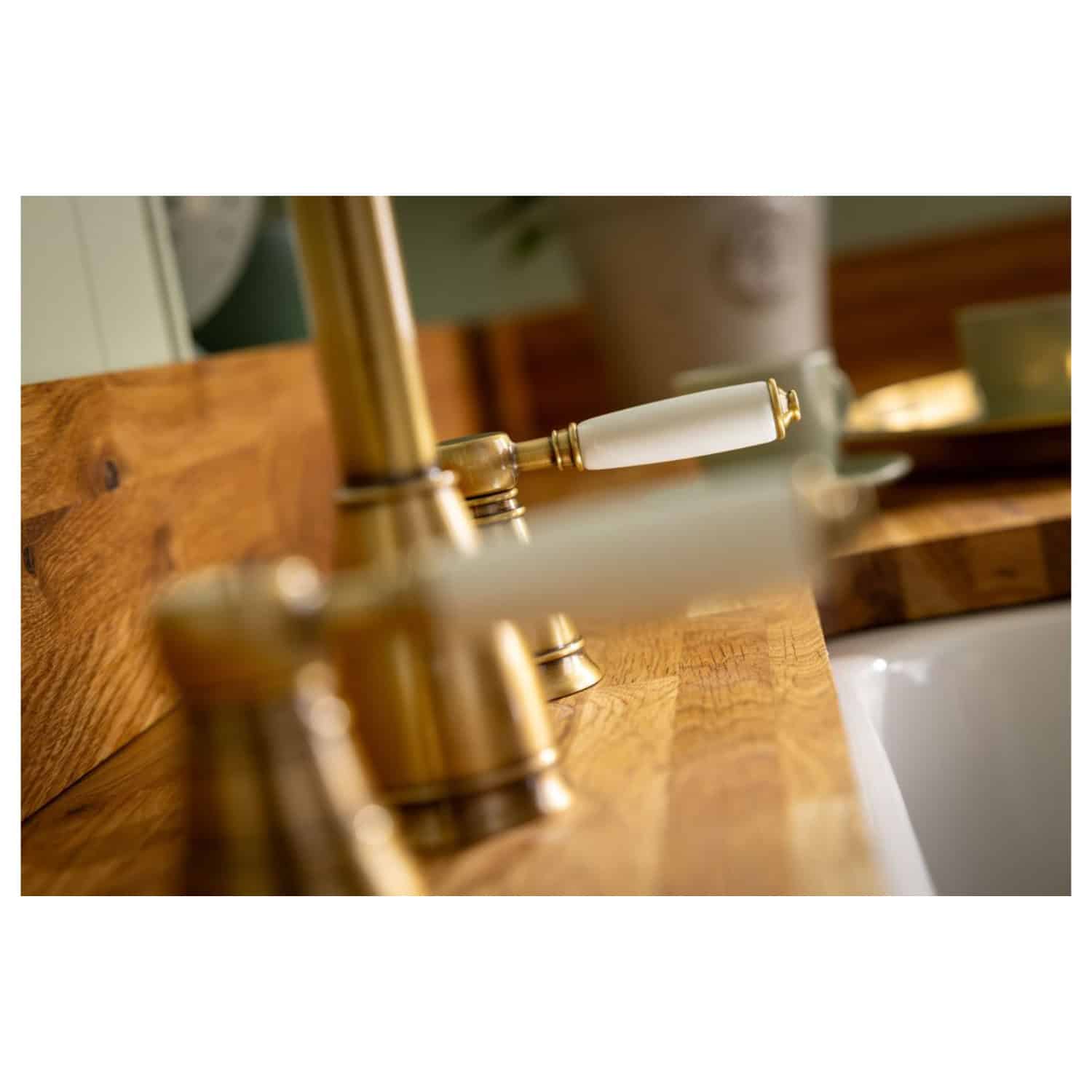 Luxurious gold and white bathroom sink faucet with a wooden countertop, creating an elegant and classic aesthetic perfect for premium Bubly Bathrooms decor.