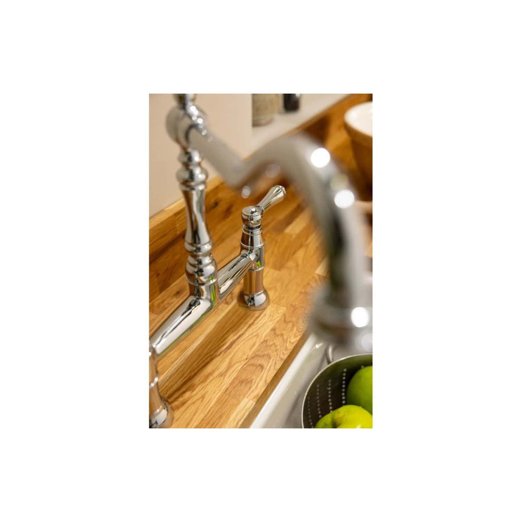 Polished chrome kitchen sink tap with a wooden countertop, close-up view in a modern bathroom or kitchen setting. Perfect for stylish and functional bathroom or kitchen designs.