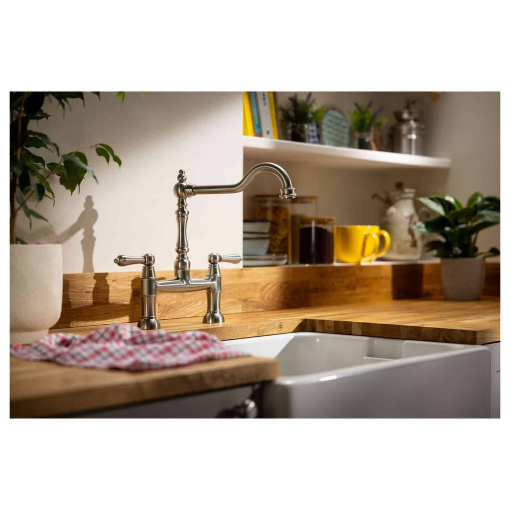 Polished chrome kitchen sink mixer tap with traditional design, set against a wooden countertop with potted plants and kitchenware, showcasing Bubly Bathrooms' stylish and functional kitchen renovation ideas.
