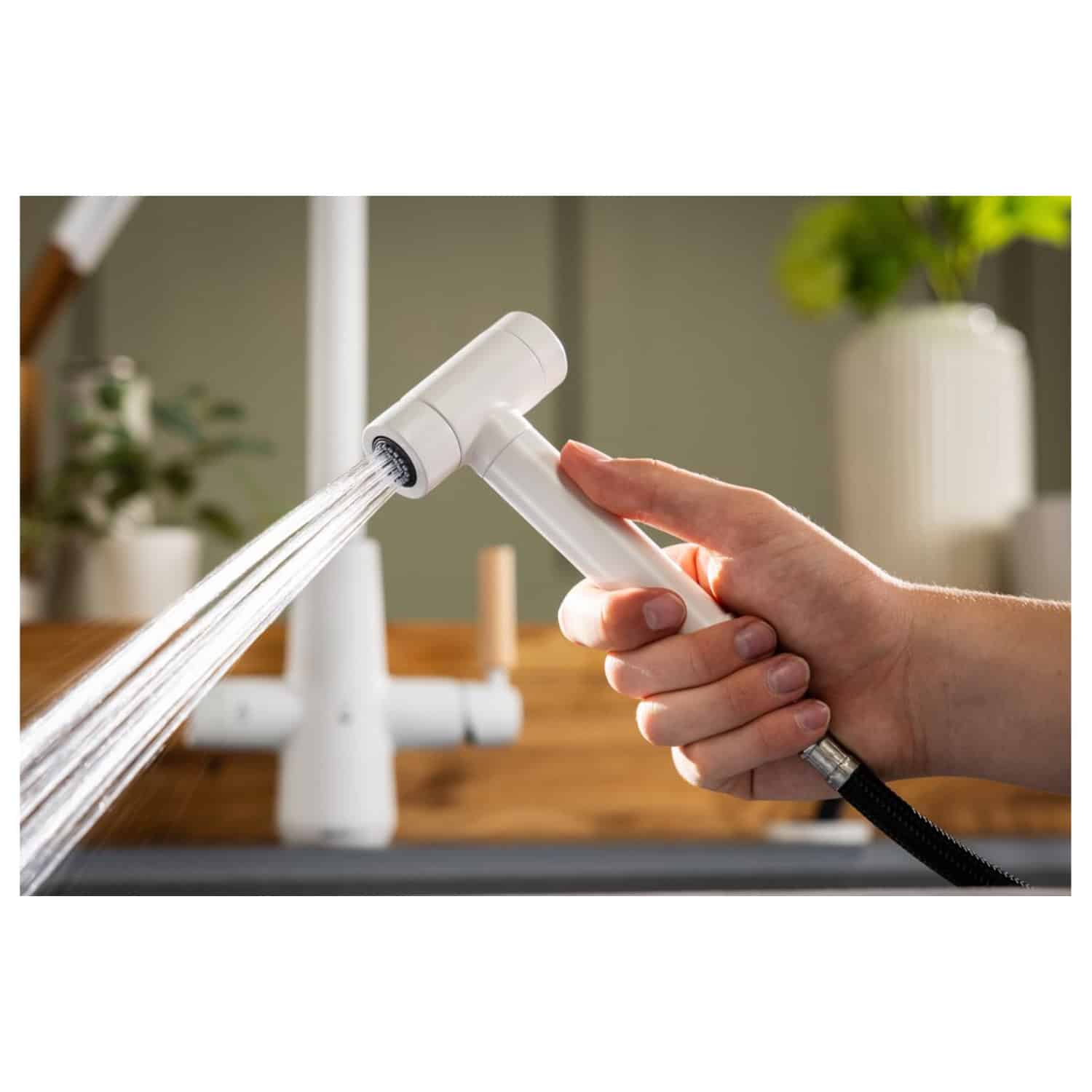Sink tap with flexible hose and water stream for bathroom or kitchen cleaning.