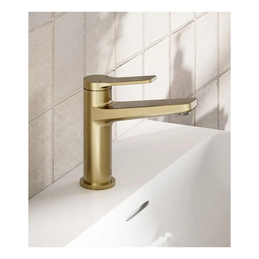 Sleek gold bathroom sink faucet installed over a modern white ceramic sink, featuring a minimalist design perfect for contemporary bathroom decor.
