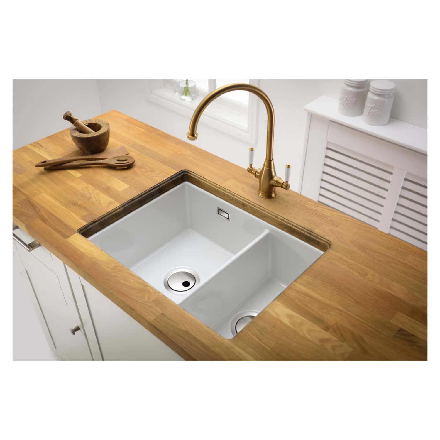 Sleek white kitchen sink with brass tap on wooden countertop, modern and stylish for contemporary bathrooms and kitchens, feature of Bubly Bathrooms.