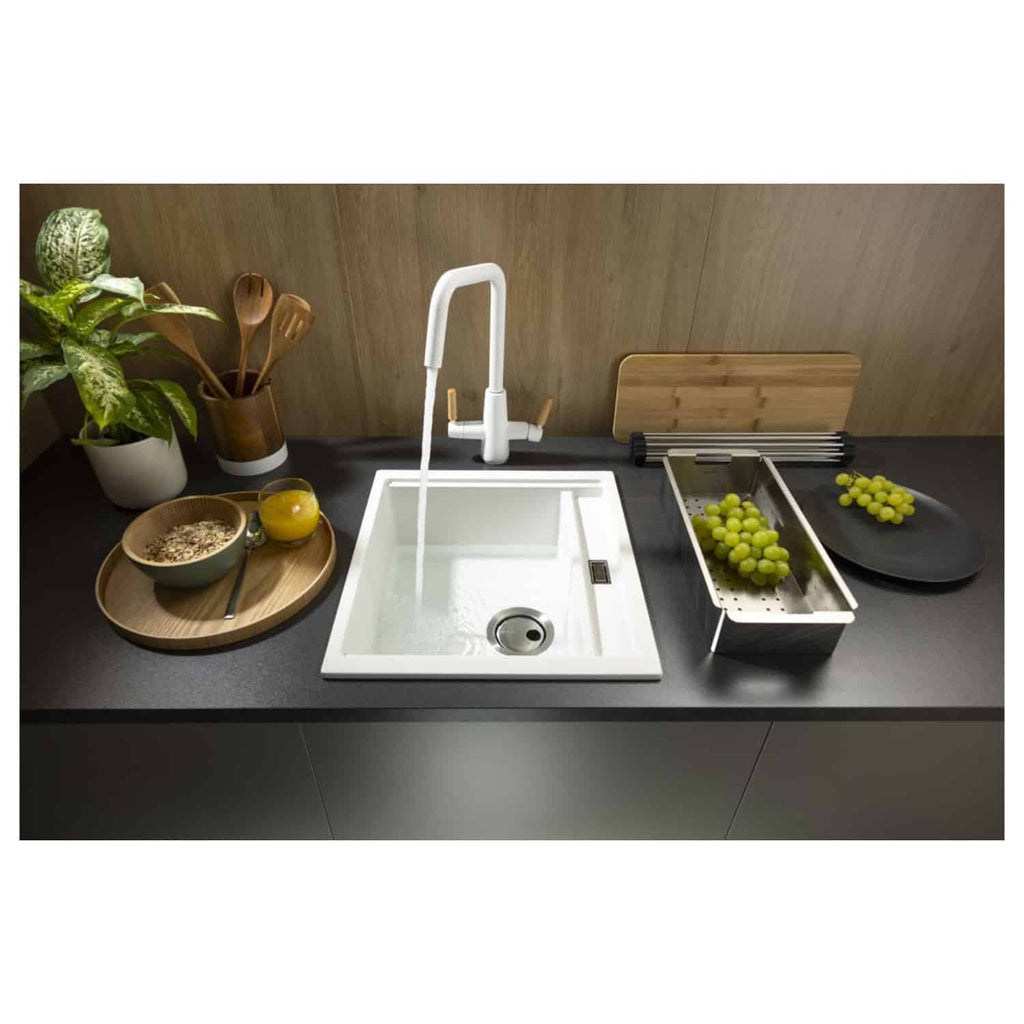 White kitchen sink with modern mixer tap and wooden kitchen accessories for kitchen renovation and design.