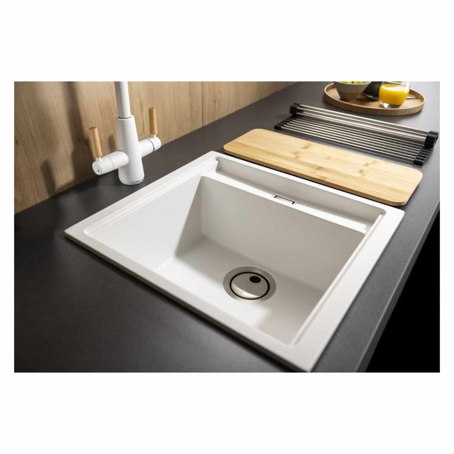 Sleek white kitchen sink with modern design, integrated drain, and minimalist tap, set in a contemporary kitchen with wooden and black countertops, featuring wooden chopping board and drying rack for kitchen convenience.