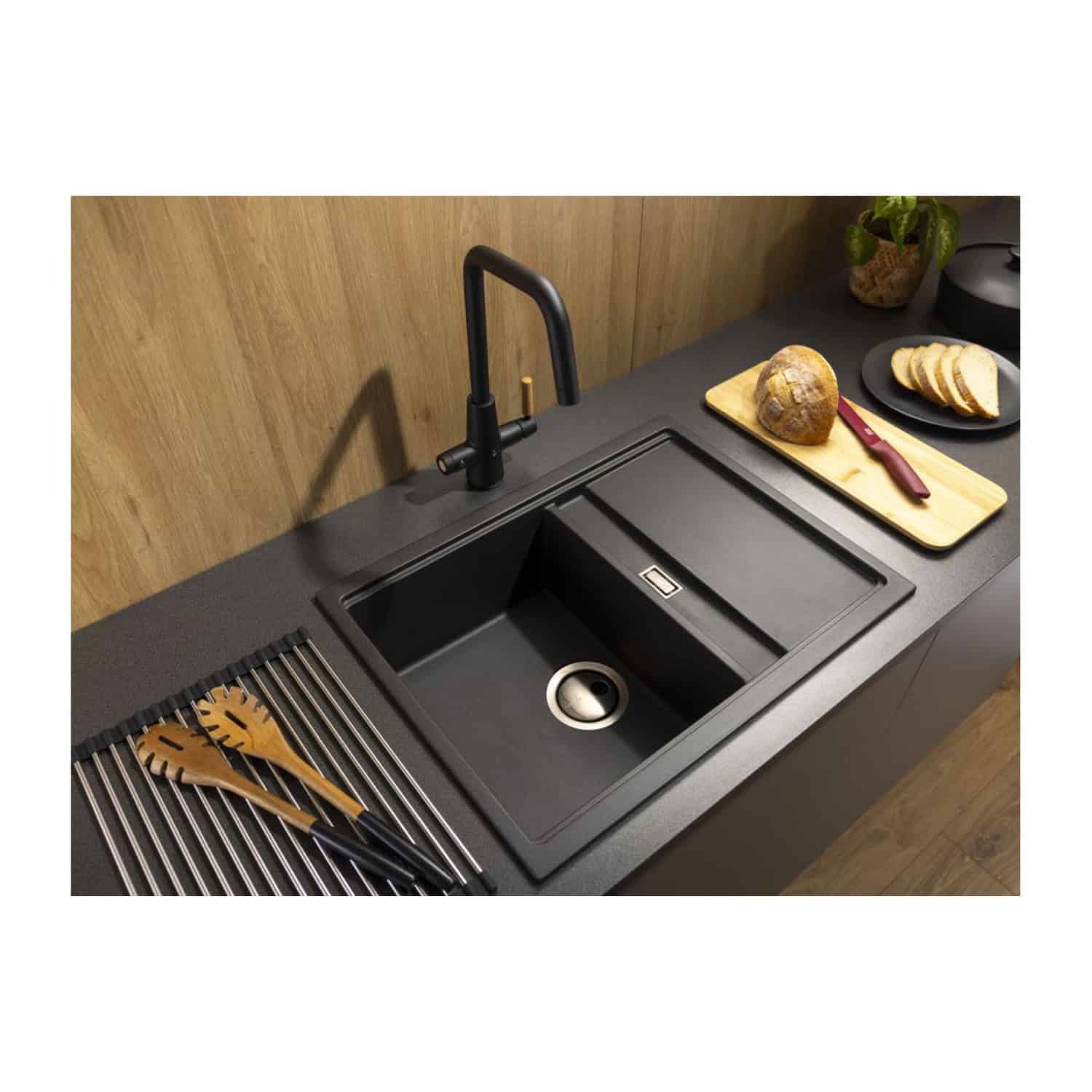 Stylish black kitchen sink with modern matte finish and black tap, set into a sleek grey countertop with black cabinetry, perfect for contemporary bathroom or kitchen design.