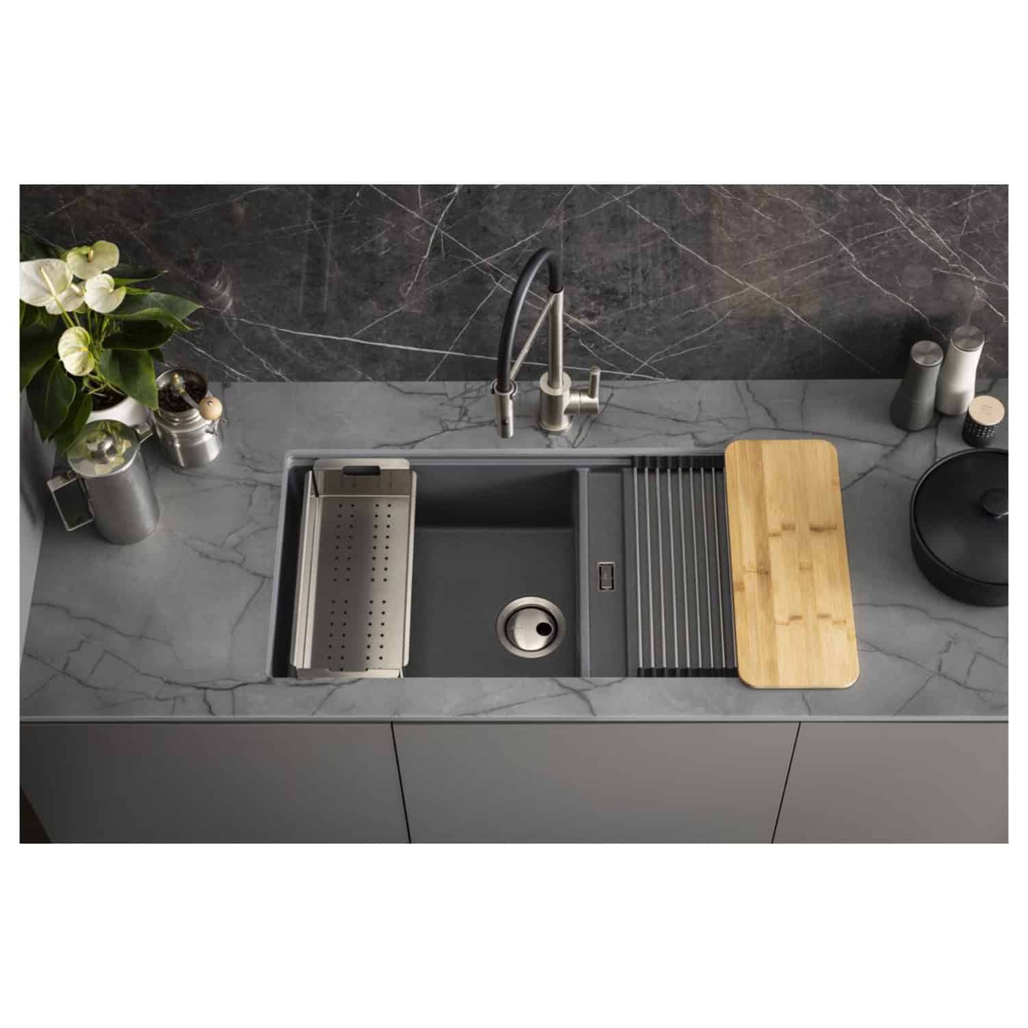 Stylish kitchen sink with grey undermount design, stainless steel accessories, and a wooden chopping board on a marble countertop, showcasing modern Bubly bathrooms and kitchen appliances.
