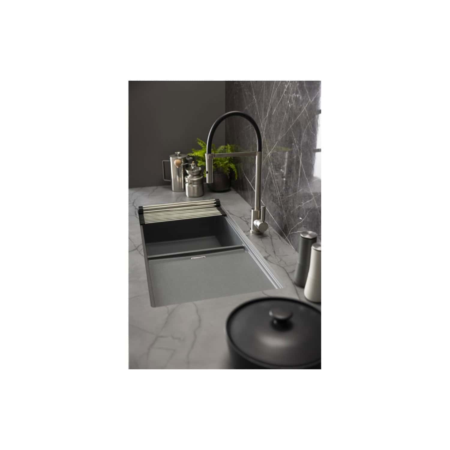 Sleek modern grey kitchen sink with a pull-out drying rack, stainless steel tap, and contemporary accessories on a marble countertop with dark marble wall tiles.