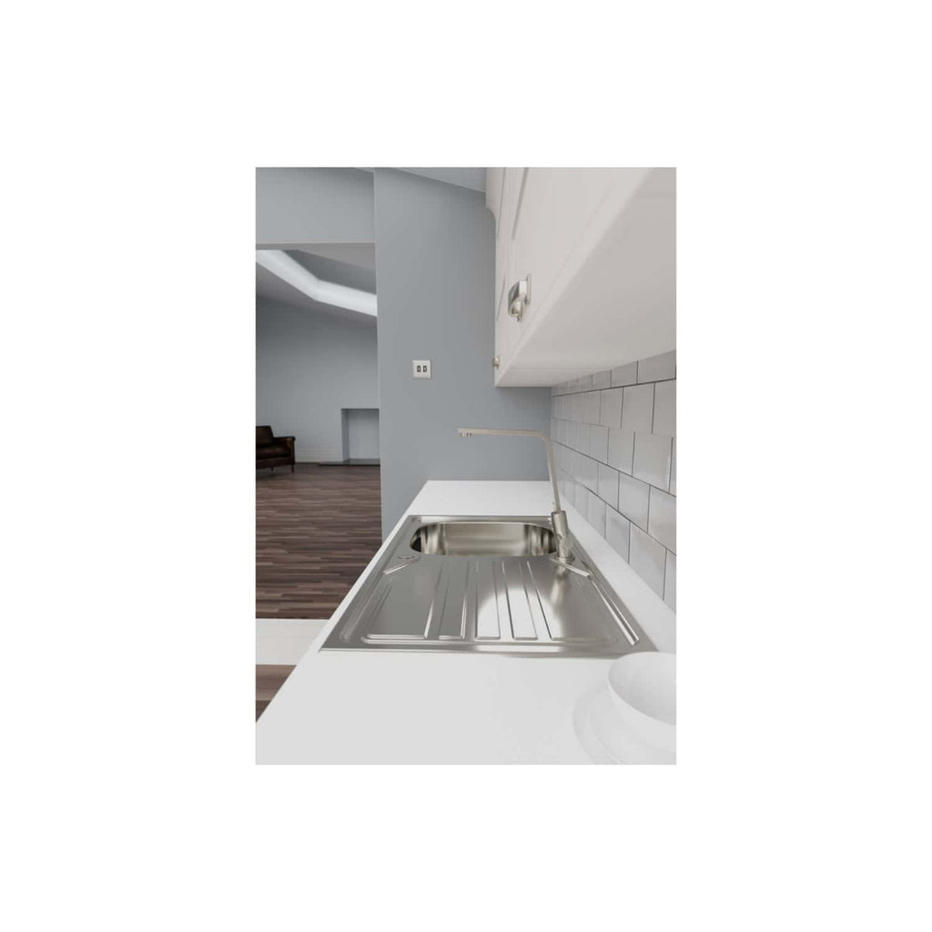 Shiny stainless steel kitchen sink integrated into a modern white countertop with a gooseneck tap, set against a white subway tile backsplash in a contemporary kitchen.