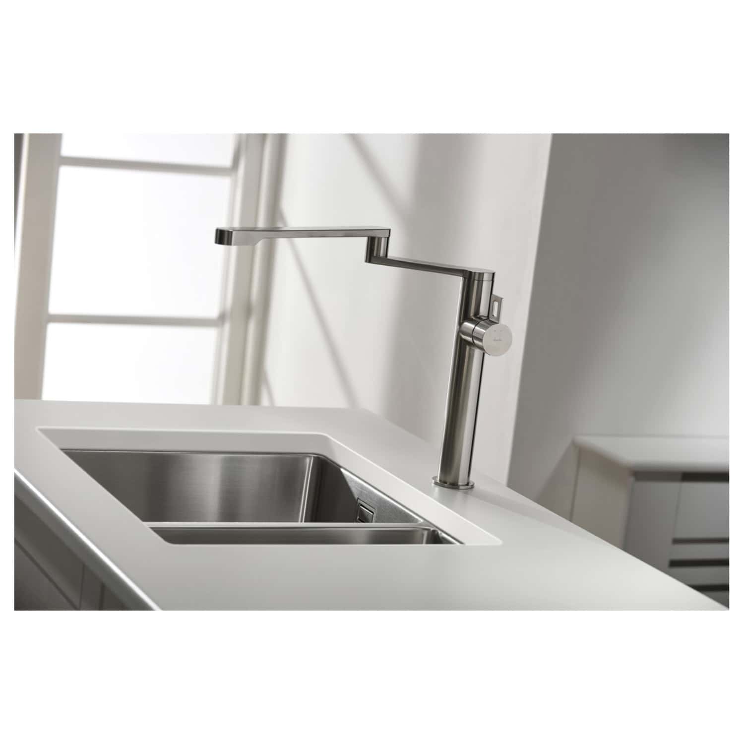 Sleek modern stainless steel kitchen sink with a contemporary pull-down faucet on a white countertop, part of a minimalist bathroom design. Perfect for stylish, functional kitchen and bathroom renovations.