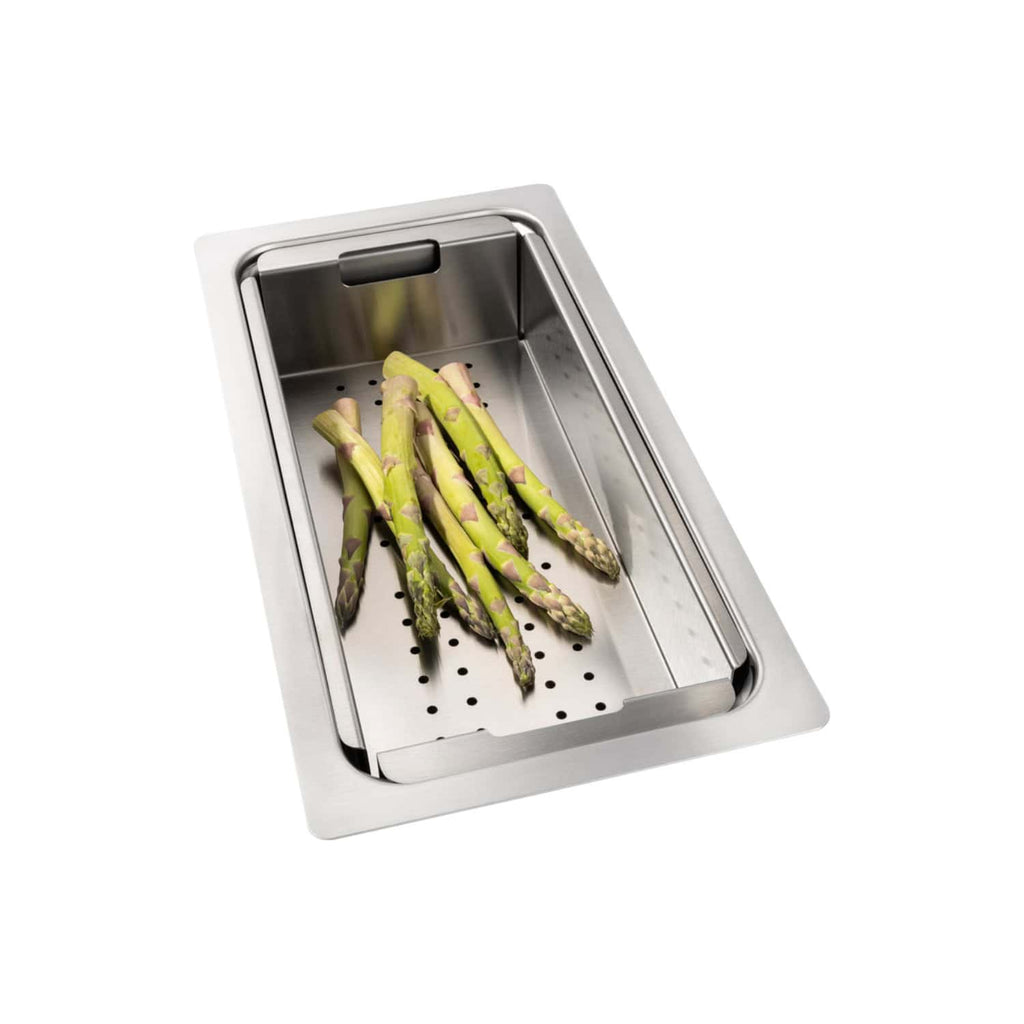 Fresh green asparagus spears on a stainless steel kitchen sink with draining board, ideal for healthy meal preparation in a modern kitchen setting.
